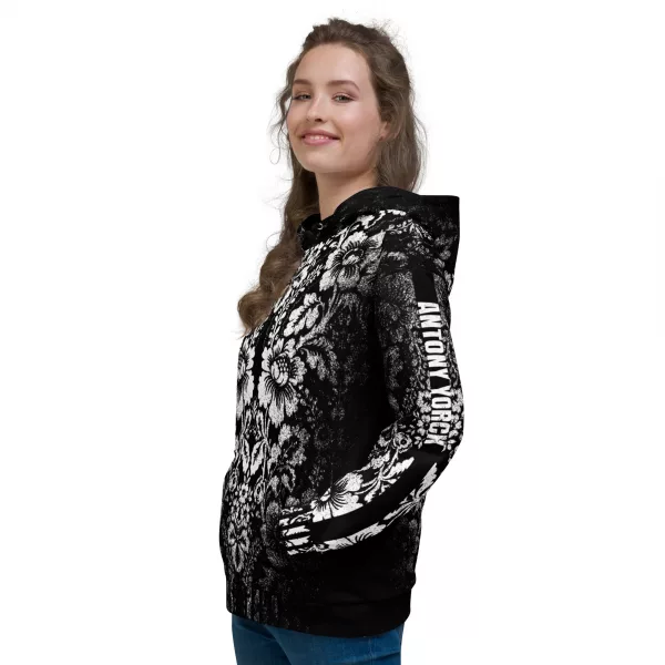 Stylischer Damen Designer Hoodie - Ein schwarzer Damenhoodie des Designer Labels ANTONY YORCK mit einem auffälligen weißen floralen Muster im baroque Noir Stil, das den gesamten Stoff bedeckt. Der Hoodie zeigt den Schriftzug "ANTONY YORCK" am Ärmel und hat eine Kapuze mit Kordelzug. Perfekt für luxury urban street style, streetwear fashion und subversive style. Entdecken Sie mehr auf https://antonyyorck.com. Schlüsselwörter: trendy womenswear, modern fashion, designer hoodie, urban clothing, stylish streetwear.