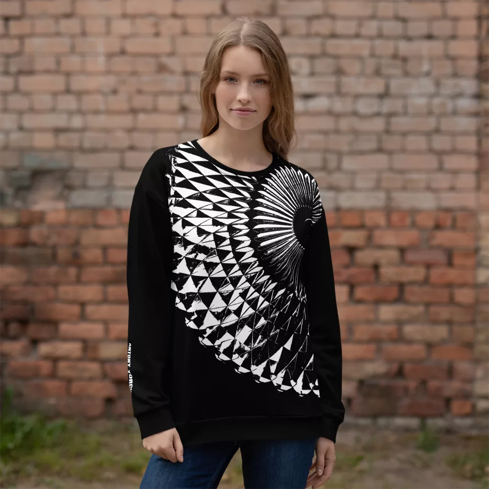 Junge Frau im Designer Pullover für Damen in schwarz mit weißem abstraktem Aufdruck vor einer Ziegelwand stehend, Vorderseite, designed by Antony Yorck, Berlin
